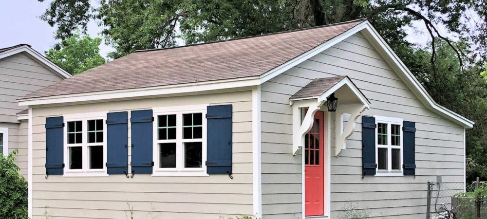 navy-blue-DIY-board-and-batten-shutters-with-black-hinges-pulls-and-shutters-dogs